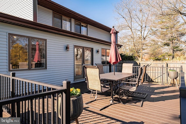 wooden terrace with outdoor dining space and fence