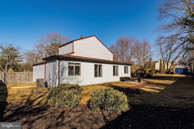 rear view of house with a lawn and fence