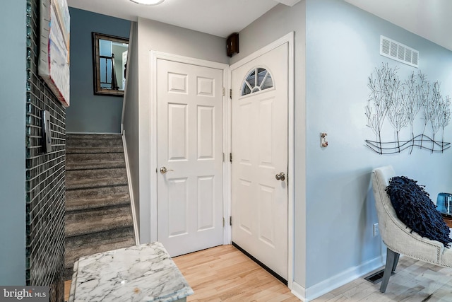 foyer with stairs, light wood-style flooring, baseboards, and visible vents