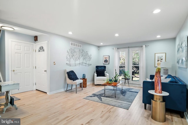 living area with recessed lighting, wood finished floors, visible vents, and baseboards