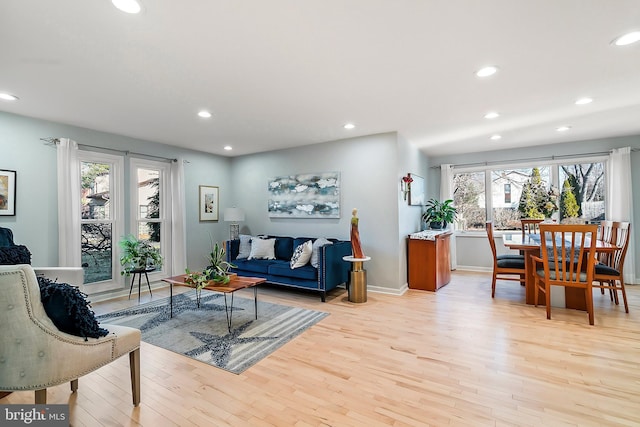 living area featuring recessed lighting, baseboards, and light wood-style floors