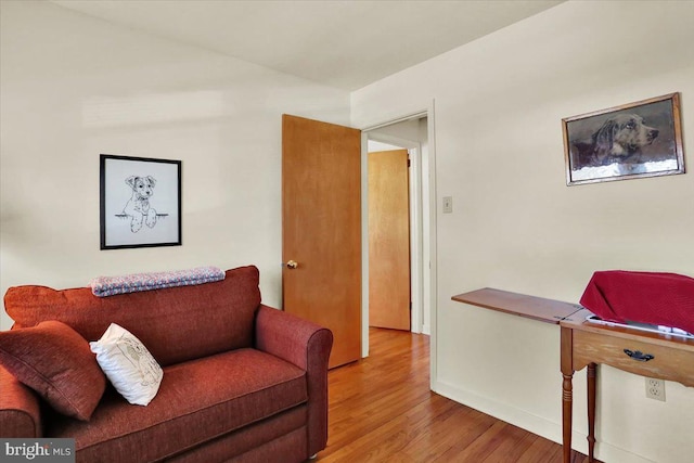 living area featuring baseboards and wood finished floors