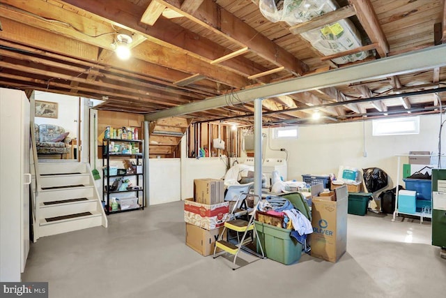 basement featuring a healthy amount of sunlight, stairs, and separate washer and dryer