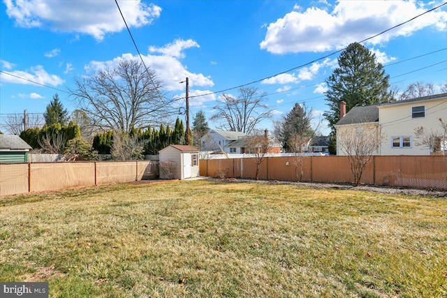 view of yard with a storage unit, an outbuilding, and a fenced backyard