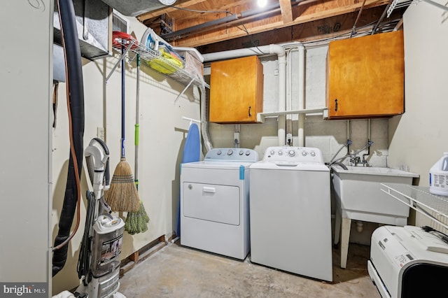 washroom with washer and dryer, cabinet space, and a sink