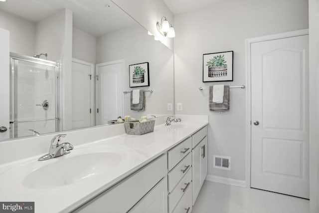 full bathroom with an enclosed shower, visible vents, double vanity, and a sink