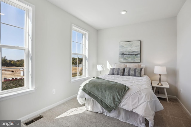 carpeted bedroom with visible vents and baseboards