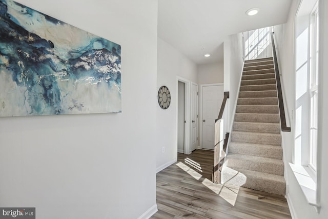 staircase featuring recessed lighting, baseboards, and wood finished floors