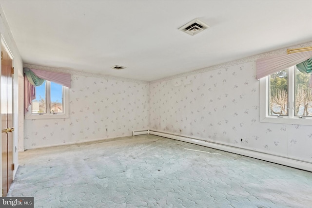 unfurnished room with visible vents, baseboard heating, a healthy amount of sunlight, and wallpapered walls