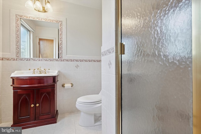 full bath with tile patterned floors, toilet, a stall shower, tile walls, and vanity