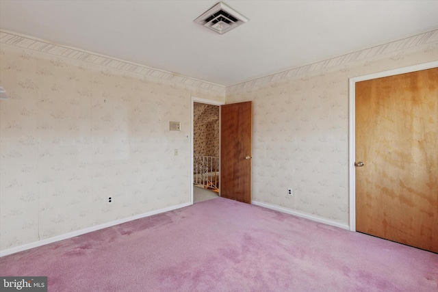 empty room featuring visible vents, carpet, and wallpapered walls