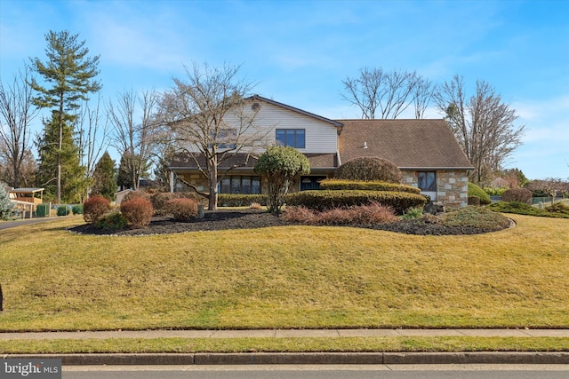 traditional home with stone siding and a front yard