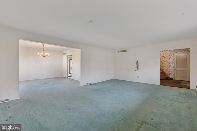 unfurnished room featuring visible vents, carpet, and a chandelier