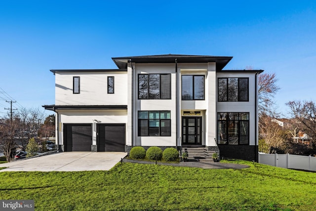 view of front facade with concrete driveway, fence, a front yard, and stucco siding