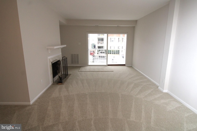 unfurnished living room with visible vents, a fireplace, baseboards, and carpet floors