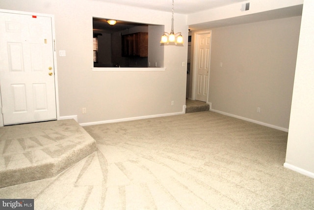 interior space featuring a notable chandelier, baseboards, visible vents, and carpet floors