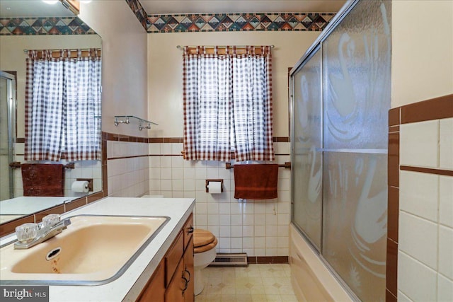 bathroom with a wainscoted wall, toilet, tile walls, and vanity