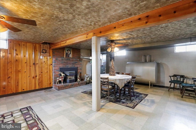 dining area with tile patterned floors, ceiling fan, heating fuel, and wood walls