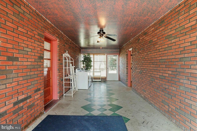 unfurnished sunroom with washer / dryer and a ceiling fan