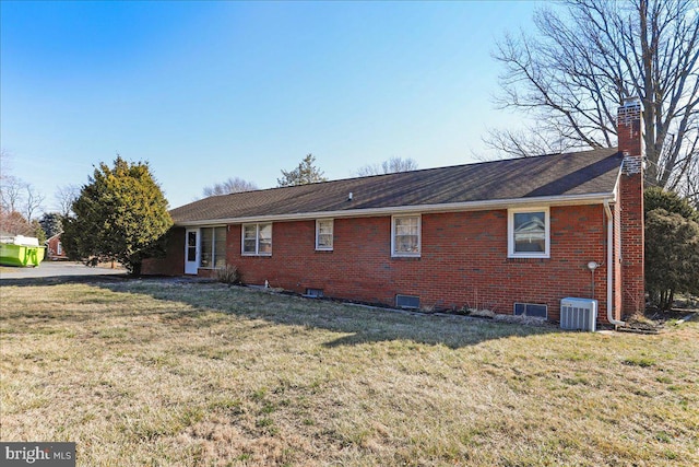 view of property exterior with brick siding, a yard, a chimney, and central AC