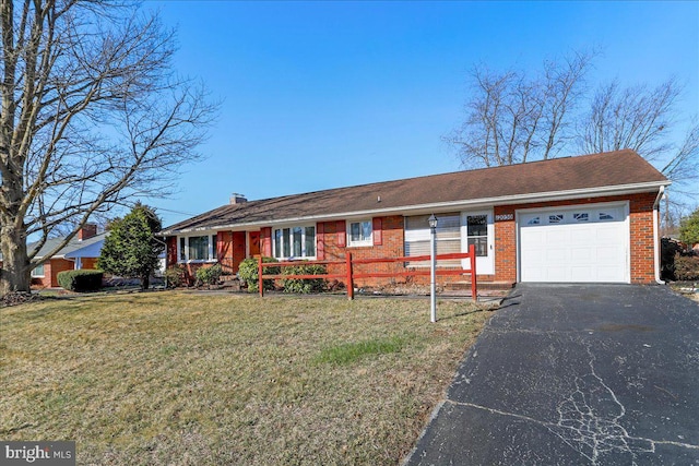 ranch-style house with a front yard, an attached garage, brick siding, and driveway