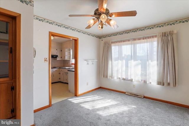 spare room with visible vents, baseboards, ceiling fan, and carpet flooring