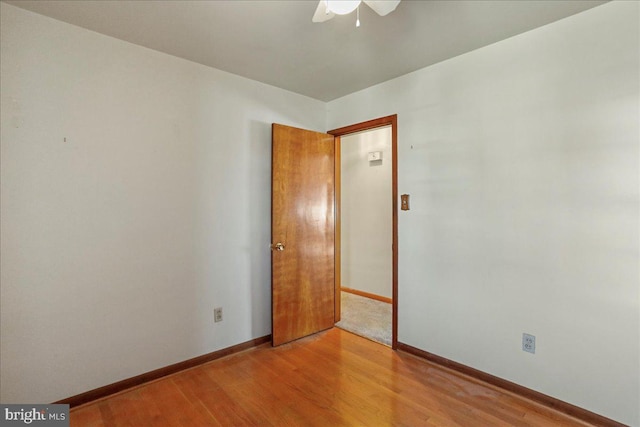 unfurnished room featuring baseboards and light wood-style flooring