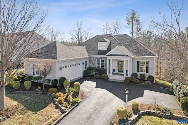 view of front of house featuring a garage, roof with shingles, and driveway