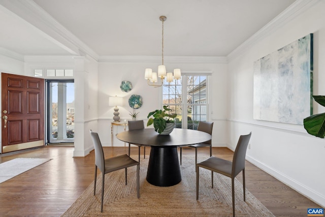 dining room with a wealth of natural light, ornamental molding, and wood finished floors