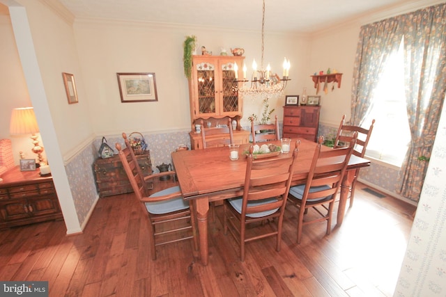 dining room featuring hardwood / wood-style floors, crown molding, visible vents, and a wainscoted wall