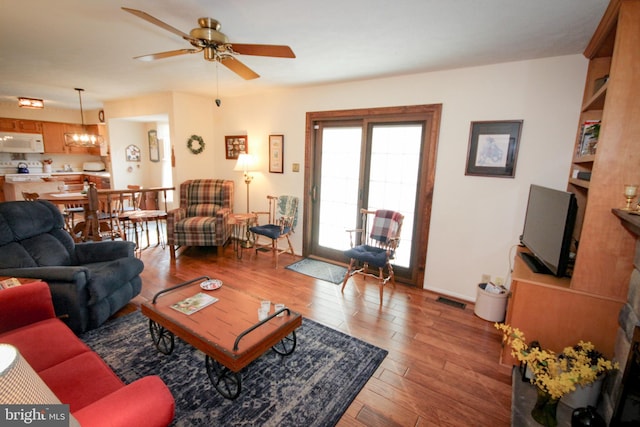 living room with visible vents, light wood-style floors, and a ceiling fan