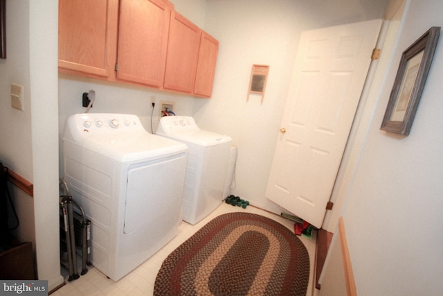 laundry area with cabinet space, independent washer and dryer, and light floors