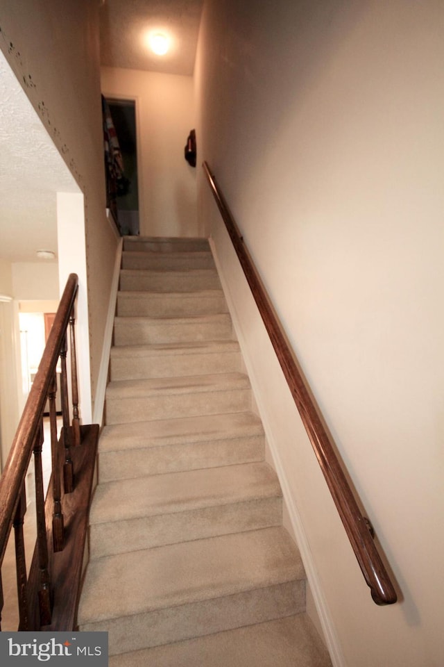 staircase with a textured ceiling