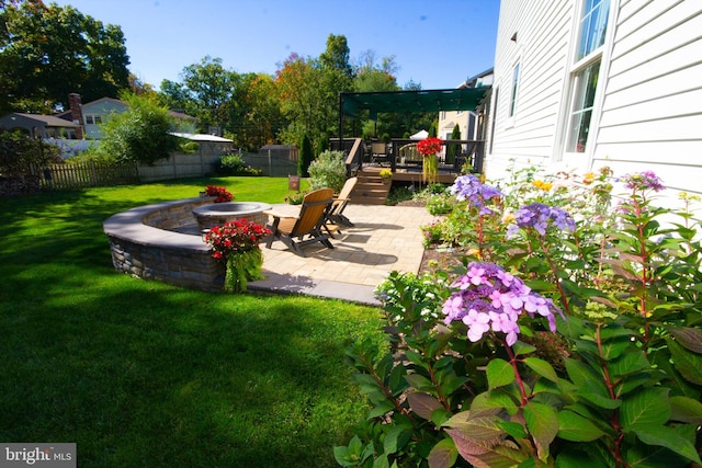 view of yard with a patio area, fence private yard, an outdoor fire pit, and a deck