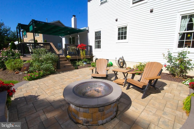 view of patio / terrace with a wooden deck and an outdoor fire pit