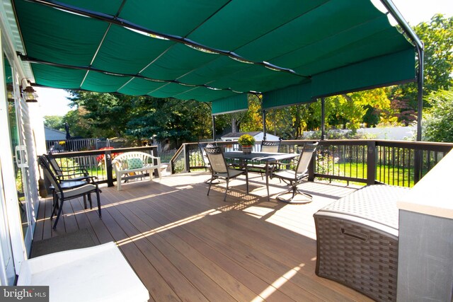 wooden deck with outdoor dining space and fence