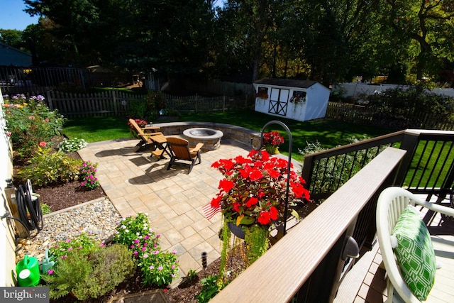 view of patio / terrace with a storage unit, a fire pit, and a fenced backyard