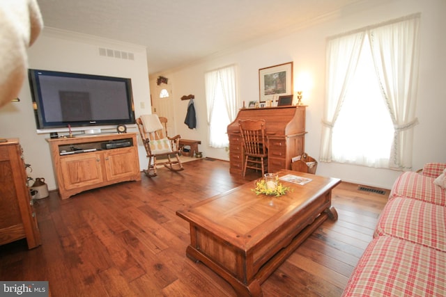 living area featuring crown molding, visible vents, and dark wood-style flooring