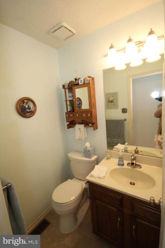 bathroom with vanity, toilet, visible vents, and tile patterned flooring