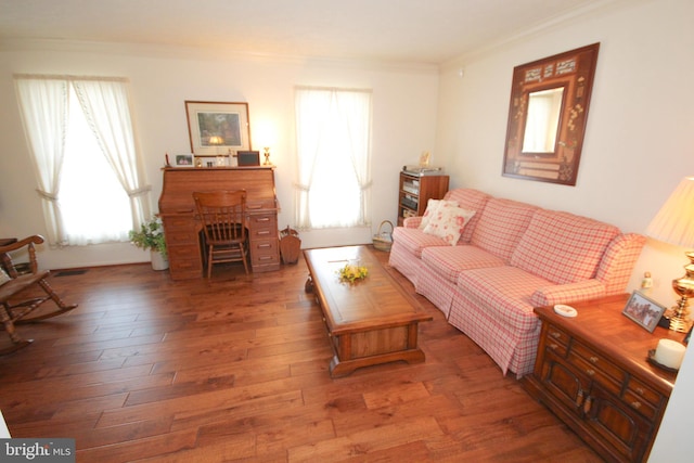 living area featuring hardwood / wood-style flooring, a healthy amount of sunlight, and ornamental molding