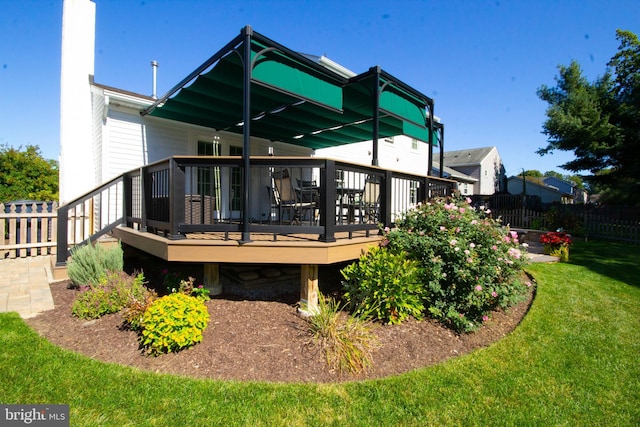 back of property featuring fence, a lawn, and a wooden deck