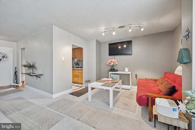 carpeted living room featuring a textured ceiling and baseboards