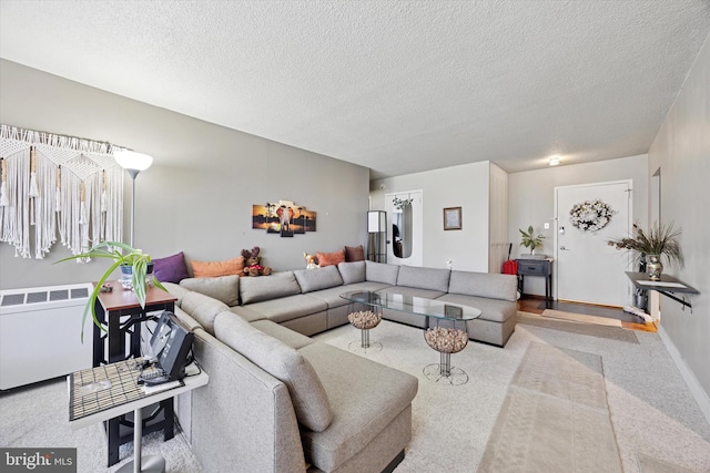 living room featuring baseboards, a textured ceiling, radiator heating unit, and carpet