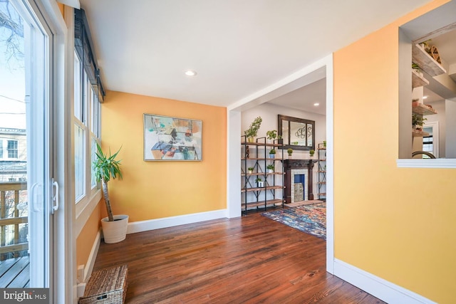 hallway with recessed lighting, wood finished floors, and baseboards