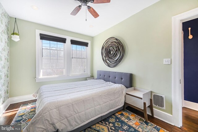 bedroom featuring visible vents, baseboards, and wood finished floors