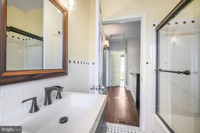 bathroom with tile walls, vanity, and wood finished floors