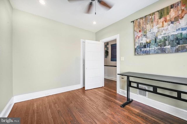 spare room with a ceiling fan, wood finished floors, and baseboards