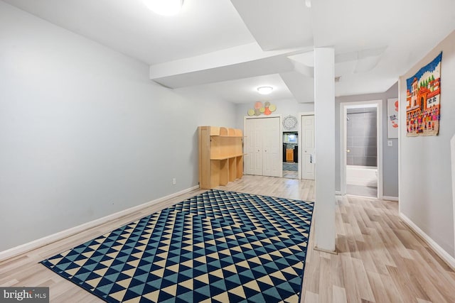 interior space featuring light wood-type flooring and baseboards