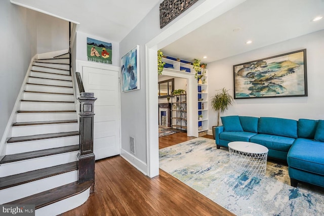 living area with visible vents, baseboards, stairs, recessed lighting, and wood finished floors