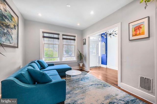 living room featuring recessed lighting, wood finished floors, visible vents, and baseboards